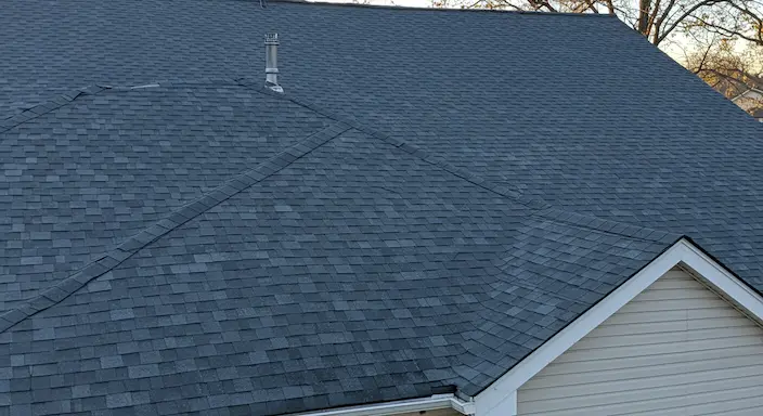 newly replaced residential roof with clean shingles and straight lines on a modern home